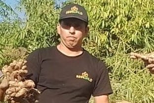 Inkawald Germany farmer holding fresh ginger root in Peruvian orchard